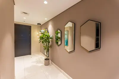 a hallway with three mirrors and a potted plant at Luxury Palm Jumeirah Apartment with Sea Views Balqis Residence in Dubai