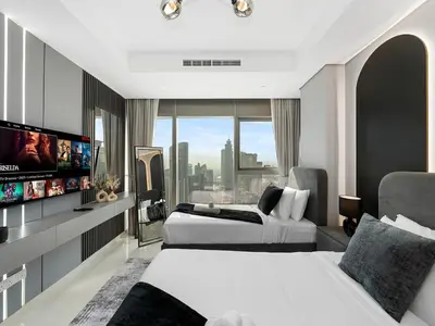 a hotel room with two beds and a flat screen tv at Famous Sky Pool - Paramount Midtown - Dubai Skyline Views in Dubai