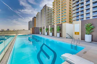 a swimming pool on the roof of a building at Charming Studio in Binghatti Galaxy JVC in Dubai