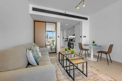 a living room with a couch and a table at Charming Studio in Binghatti Galaxy JVC in Dubai