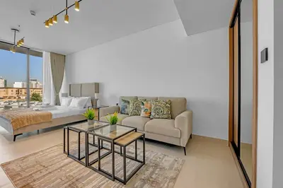a living room with a couch and a table at Charming Studio in Binghatti Galaxy JVC in Dubai