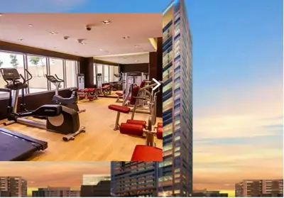 a gym with exercise equipment and a tall building at Glamorous Luxe Studio in Ghalia-JVC-12 in Dubai