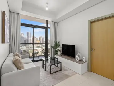 a living room with a couch and a television at Sophisticated 2BDR Living In Aykon City Business B in Dubai