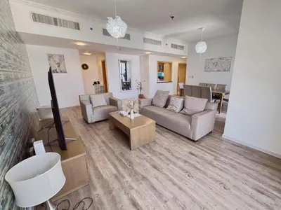 a living room with a couch and a table at JBR l Full Sea View l 4BR l 3min to Beach l 7-12PAX in Dubai