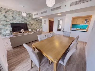 a dining room and living room with a table and chairs at JBR l Full Sea View l 4BR l 3min to Beach l 7-12PAX in Dubai