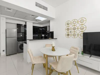 a kitchen with a table and chairs and a tv at Signature Prestige 1BR Sleeps 4 -Damac Central in Dubai