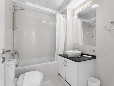 a white bathroom with a sink and a toilet at Signature Prestige 1BR Sleeps 4 -Damac Central in Dubai