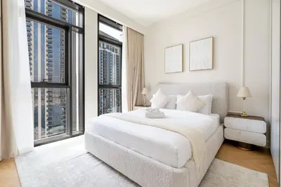 a white bedroom with a large bed and large windows at New! Elegant 1BR Flat in Creek Harbour with Pool&Gym in Dubai
