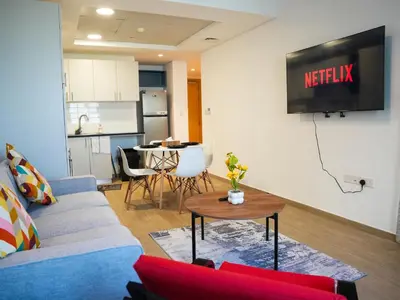 a living room with a couch and a table at 2BR Next to Metro and EXPO City GYM Pool Playground in Dubai