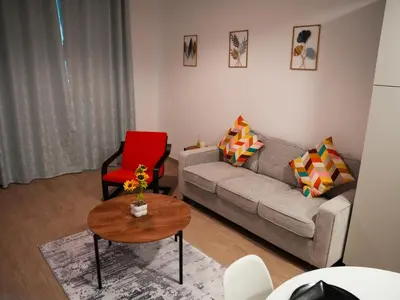 a living room with a couch and a table at 2BR Next to Metro and EXPO City GYM Pool Playground in Dubai