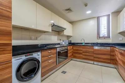 a kitchen with a washer and a washing machine at New! Serene 2BR with Balcony & Pool in Sparkle Tower in Dubai