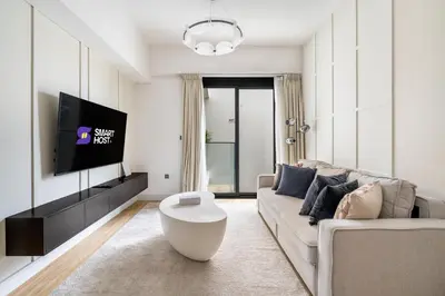 a living room with a couch and a tv at New! Stylish 1BR with Balcony and Pool Elysee III JVC in Dubai