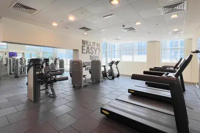 a gym with rows of treadmills and exercise machines at Silk Valley - Luxury 2BR in Downtown near Burj Khalifa & Dubai Mall in Dubai