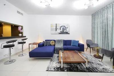 a living room with a blue couch and a table at Silk Valley - Luxury 2BR in Downtown near Burj Khalifa & Dubai Mall in Dubai