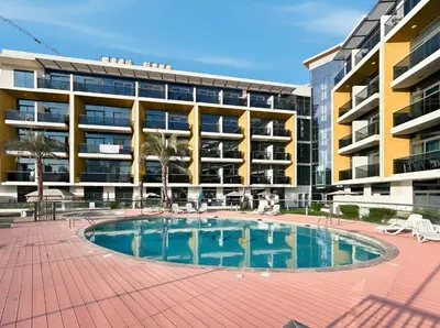 a swimming pool in front of a building at New! Serene Studio with Balcony and Pool Crystal Res in Dubai