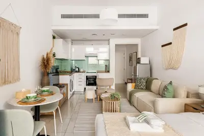 a living room with a couch and a table at New! Serene Studio with Balcony and Pool Crystal Res in Dubai