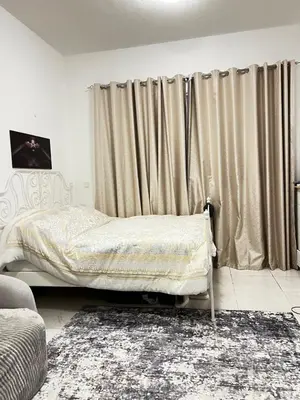 a bedroom with a bed and a window with curtains at Studio in Dubai