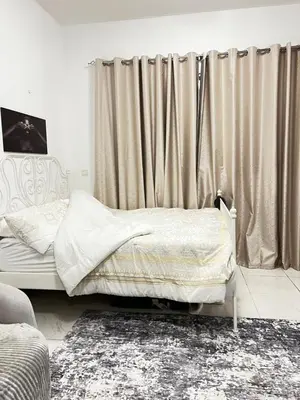a bedroom with a bed and a window with curtains at Studio in Dubai