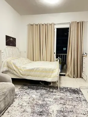 a bedroom with a bed and a window with curtains at Studio in Dubai