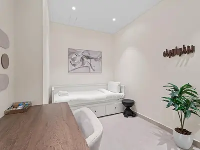 a white living room with a couch and a table at Urban Compact 2BKH Sleeps 4 Full Burj Khalifa View in Dubai