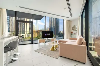 a living room with a couch and a large window at New! Spacious 2BR with Burj Views in Marquise Square in Dubai