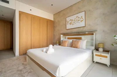 a bedroom with a large white bed in a room at New! Spacious 2BR with Burj Views in Marquise Square in Dubai