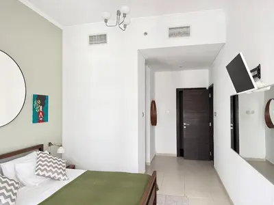 a white bedroom with a bed and a hallway at Cayan Tower, Dubai Marina in Dubai