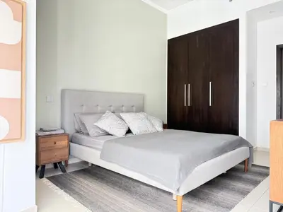 a bedroom with a bed and a wooden cabinet at Cayan Tower, Dubai Marina in Dubai
