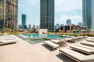 a pool with lounge chairs and a city skyline at Brand New Luxury Waterfront 2bd Beautiful Canal View in Dubai