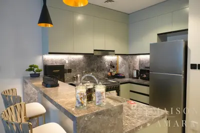 a kitchen with a sink and a refrigerator at Luxury 1BR Apartment - DAMAC Hills - Infinity Pool in Dubai