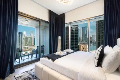 a bedroom with a large bed and a large window at Luxury 3 Bedroom Apartment, 8 mins from Dubai Mall, Sleeps 6 people in Dubai