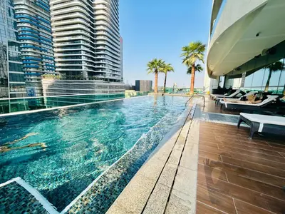 a swimming pool on a building with palm trees at Sunrise Homes A Beautiful Studio in Downtown in Dubai