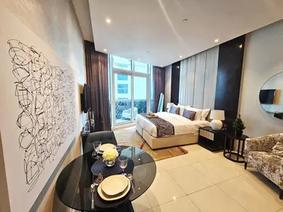 a living room with a bed and a glass table at Sunrise Homes A Beautiful Studio in Downtown in Dubai