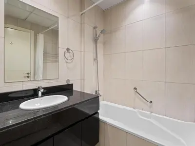 a bathroom with a sink and a mirror and a tub at Relaxing Stay Studio in Ghalia 29 in Dubai
