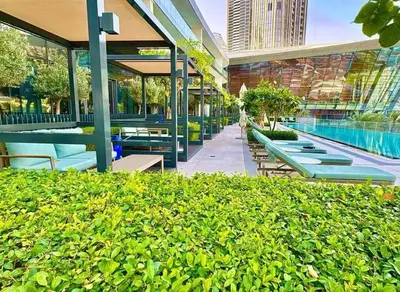 a building with benches and a swimming pool in a courtyard at Grande Essence Elegant 1BR Sleeps 4 in Downtown in Dubai