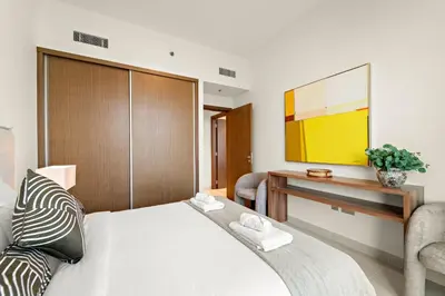 a bedroom with a bed and a desk and a tv at Luxe 2BR with Full Marina Views & Beach Access in Dubai