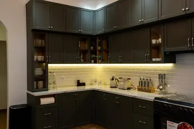 a kitchen with black cabinets and white counter tops at Iconic Villa in Dubai