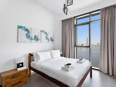 a bedroom with a bed and a large window at Creek Harbour Gem Stylish 2BR with Stunning Views-17 in Dubai
