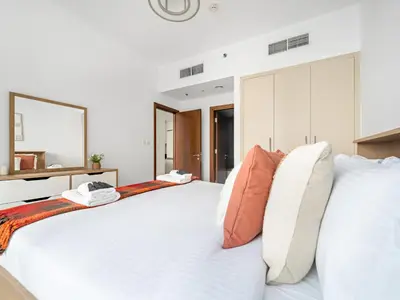 a bedroom with a large white bed with pillows at Charming City View w 1BDR Apartment In Noura Tower in Dubai