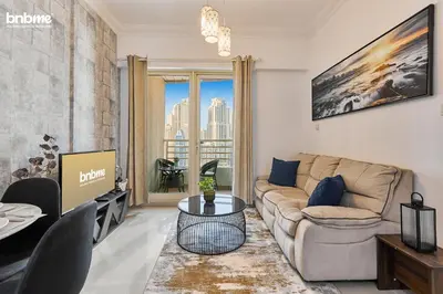 a living room with a couch and a table at bnbmehomes - Manchester Tower in Dubai