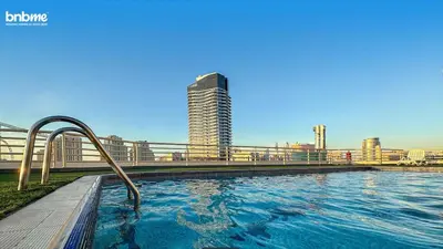 a swimming pool in a city with a tall building at bnbmehomes - Manchester Tower in Dubai