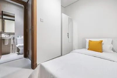 a white bedroom with a yellow pillow on a bed at 2BR plus M CF7 B Partial Canal View in Dubai
