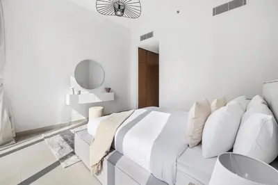 a white bedroom with a white couch and a mirror at 2BR plus M CF7 B Partial Canal View in Dubai