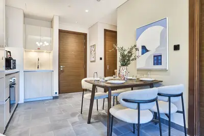 a dining room with a table and chairs in a kitchen at STAY BY LATINEM Luxury 1BR Holiday Home CB 0618 Near Burj Khalifa in Dubai