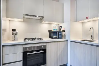 a kitchen with white cabinets and a stove top oven at STAY BY LATINEM Luxury 1BR Holiday Home CB 0618 Near Burj Khalifa in Dubai