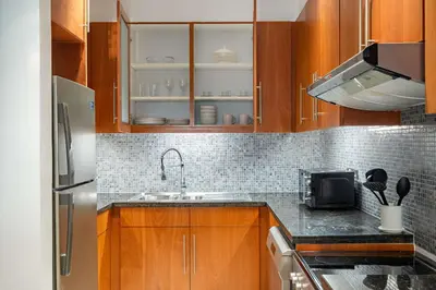 a kitchen with wooden cabinets and a sink at Silkhaus Entrepreneur Work & Stay Studio in DIFC in Dubai