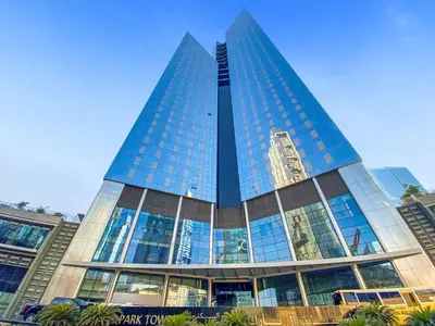 a tall building with glass windows in a city at Silkhaus Entrepreneur Work & Stay Studio in DIFC in Dubai