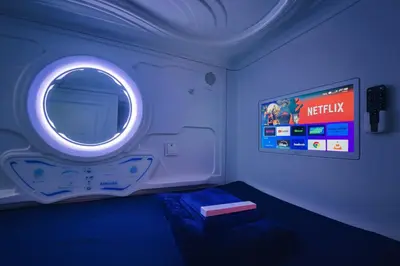 a bedroom with a round window and a tv at Teremok Holiday Homes in Dubai