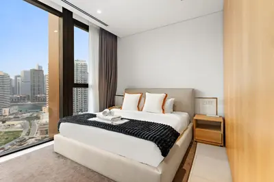 a bedroom with a large bed and a large window at Spacious 2BR in Business Bay with Canal View in Dubai