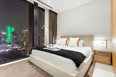 a bedroom with a large bed and a large window at Spacious 2BR in Business Bay with Canal View in Dubai
